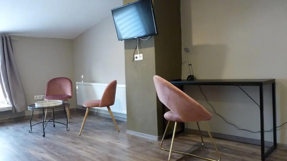 Ecke mit Schreibtisch, Stühlen und TV